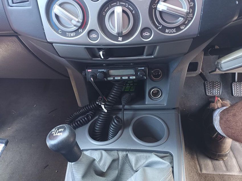 A Man is Sitting in a Car With a Walkie Talkie on the Dashboard — South West 4WD Wreckers In Brisbane, QLD