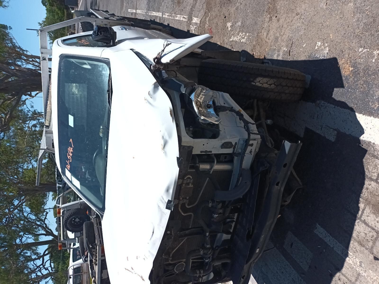 A Damaged White Car is Parked on the Side of the Road — South West 4WD Wreckers In Brisbane, QLD