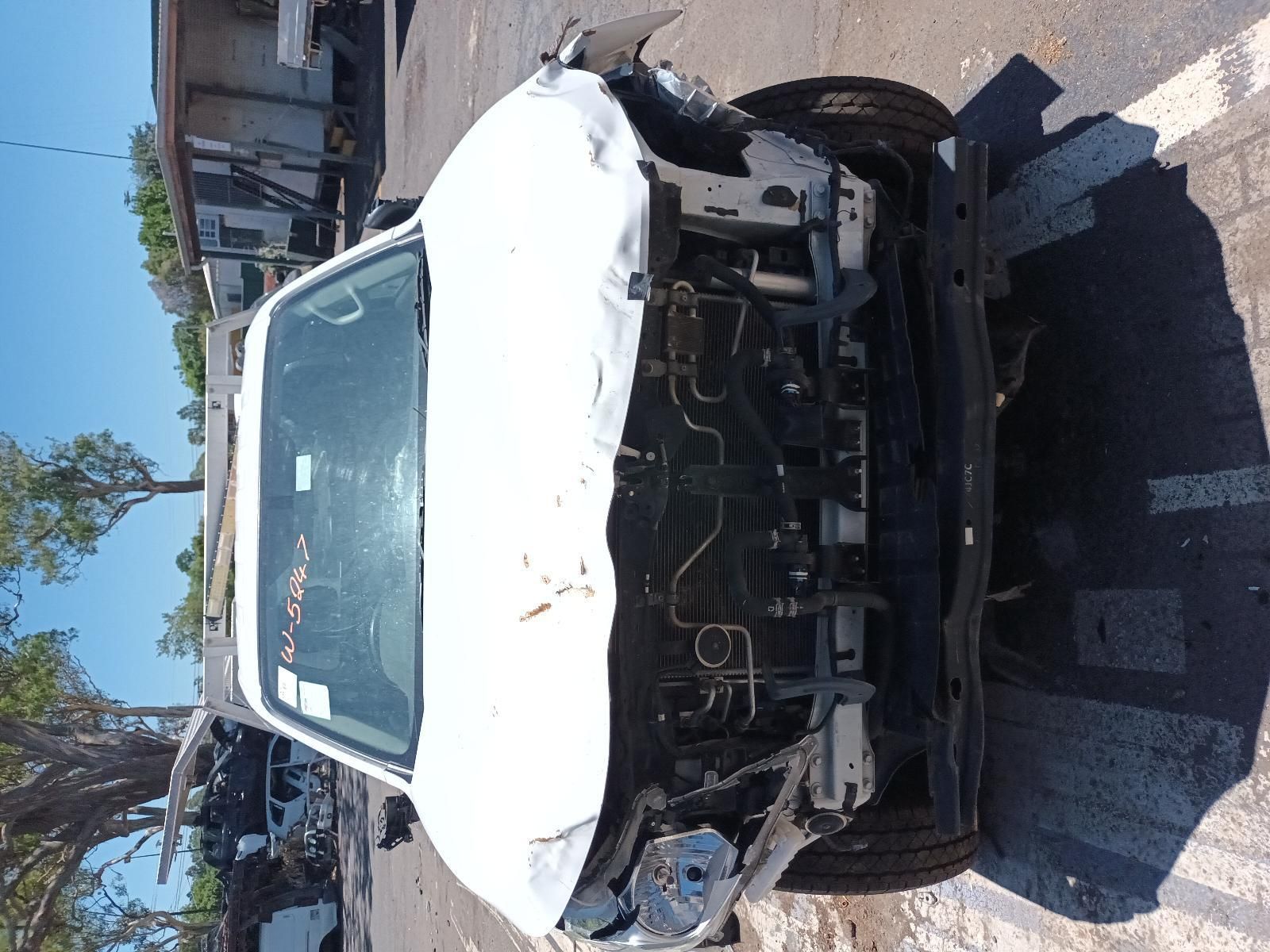 A Wrecked White Car is Sitting on the Side of the Road — South West 4WD Wreckers In Brisbane, QLD