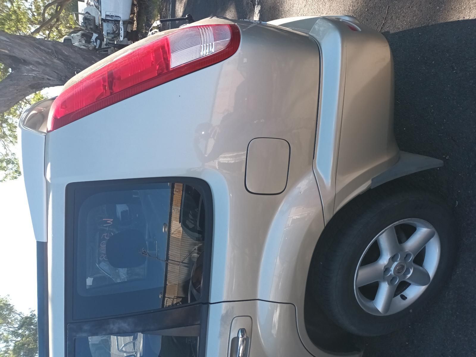 A White Car with a Red Tail Light is Parked on the Side of the Road — South West 4WD Wreckers in Harristown, QLD