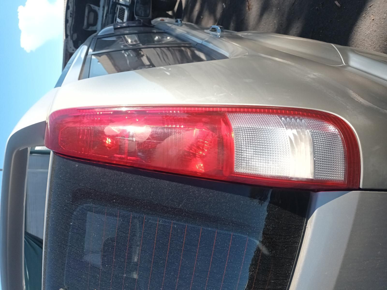 A Silver Car with a Red Tail Light is Parked on the Side of the Road — South West 4WD Wreckers in Harristown, QLD