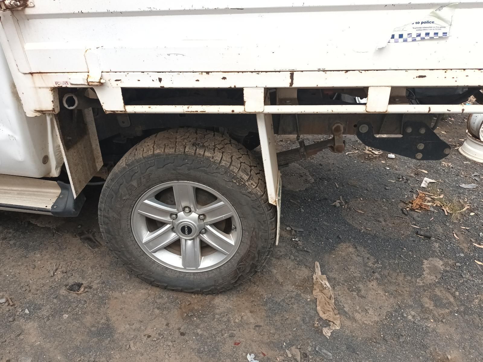 A White Truck with a Flat Tire is Parked on the Ground — South West 4WD Wreckers In Brisbane, QLD