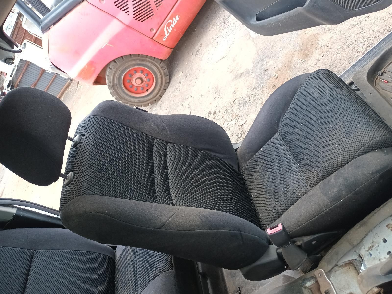 A Black Car Seat with a Red Forklift in the Background — South West 4WD Wreckers In Brisbane, QLD