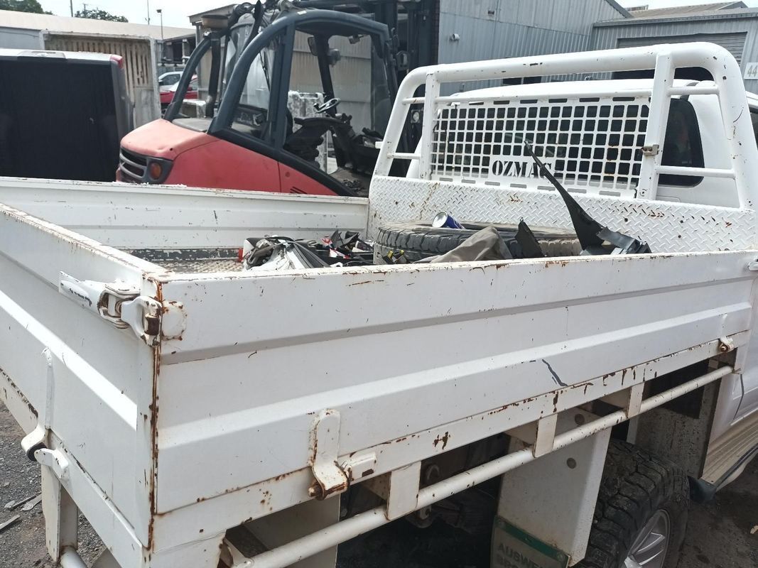 A White Truck Bed with a Forklift in the Background — South West 4WD Wreckers In Brisbane, QLD