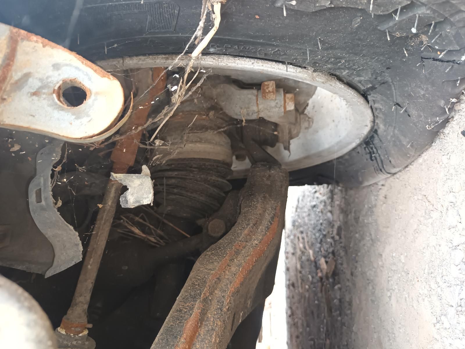 A Close Up of the Underside of a Car with a Tire in the Background — South West 4WD Wreckers In Brisbane, QLD