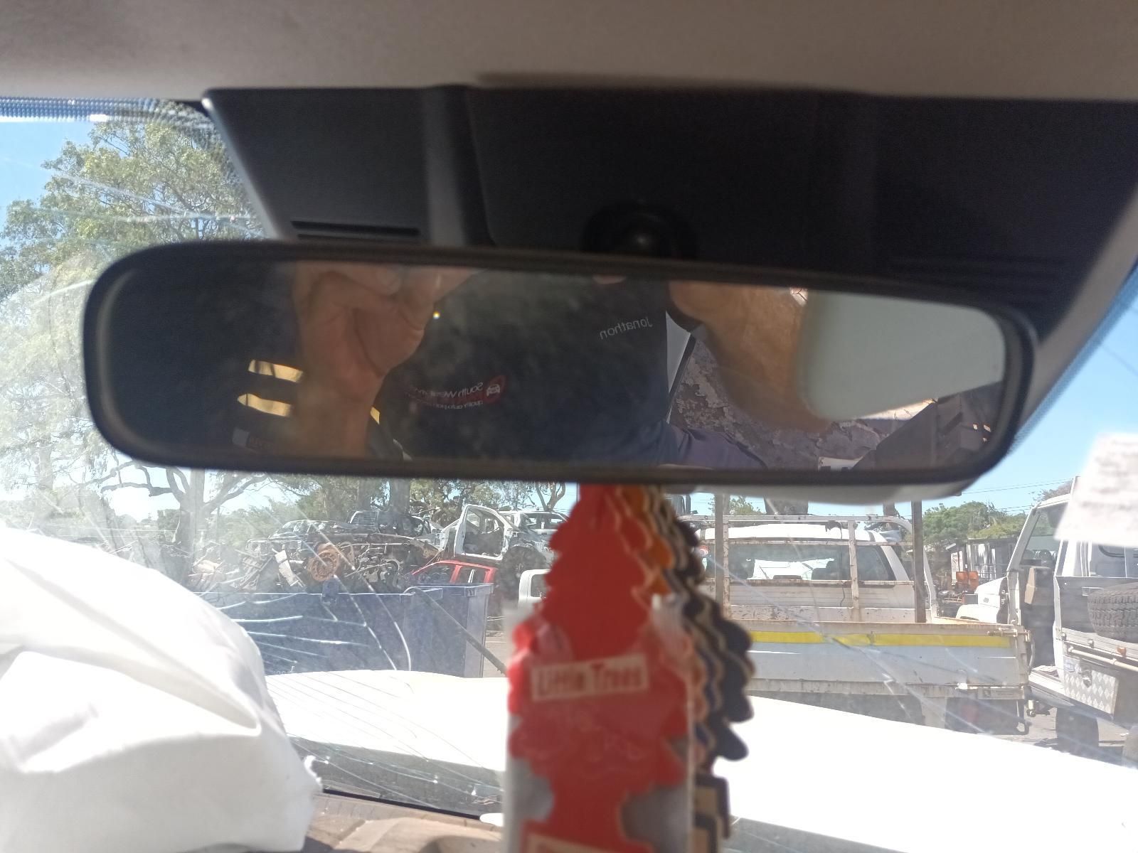 A Rear View Mirror in a Car Shows a Man Talking on a Cell Phone — South West 4WD Wreckers in Harristown, QLD