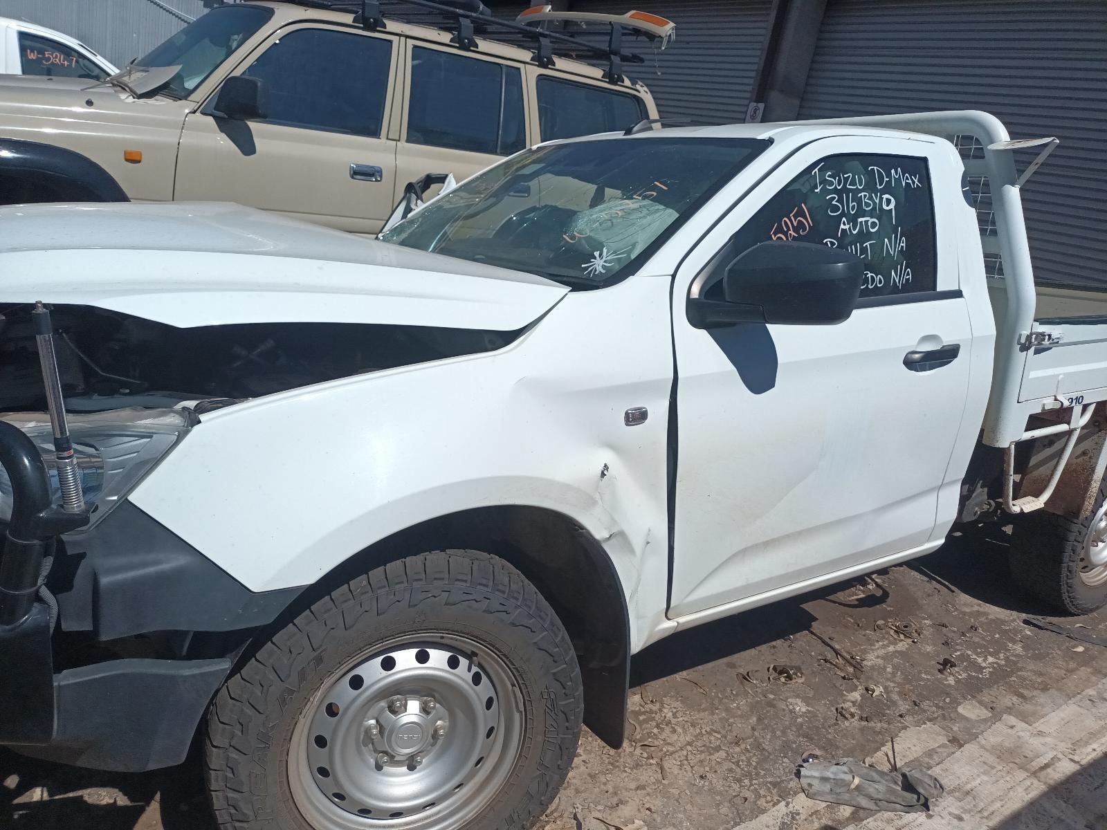 A White Truck with a Damaged Hood is Parked in the Dirt — South West 4WD Wreckers in Harristown, QLD