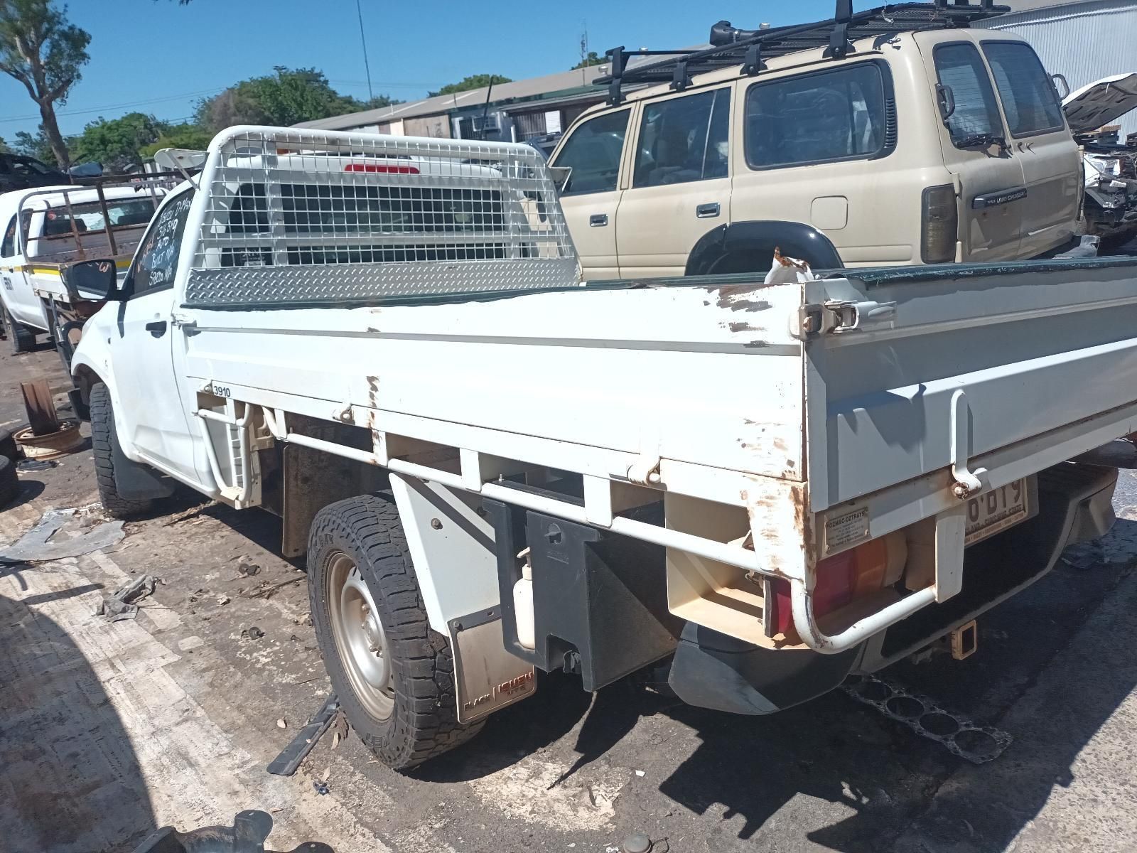 A White Truck is Parked in a Lot with Other Cars — South West 4WD Wreckers in Harristown, QLD