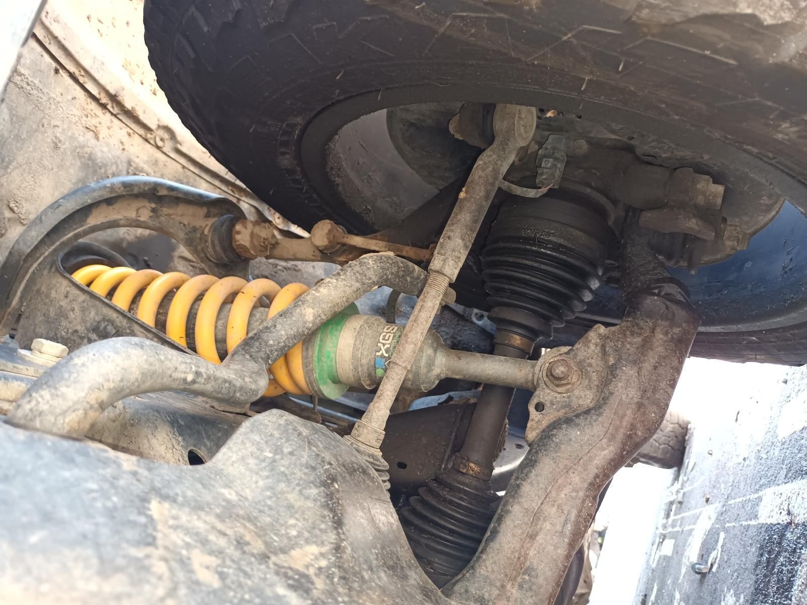 A Close Up of the Underside of a Car with a Yellow Shock Absorber — South West 4WD Wreckers In Brisbane, QLD