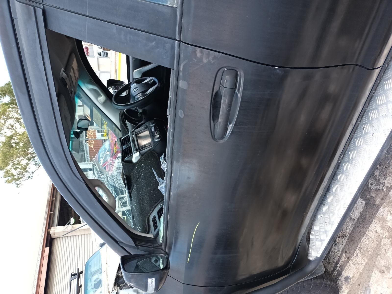 A Black Car with a Broken Window is Parked on the Side of the Road — South West 4WD Wreckers In Brisbane, QLD