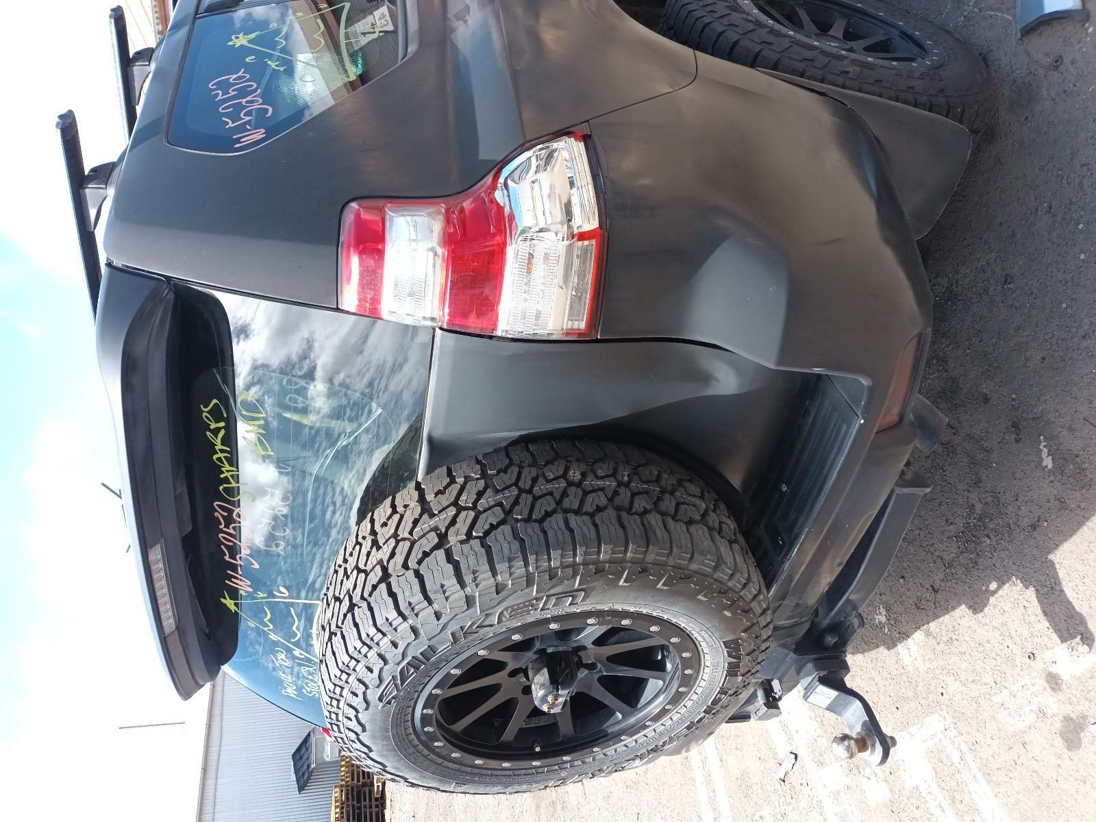 A Black SUV with a Spare Tire is Parked on the Side of the Road — South West 4WD Wreckers In Brisbane, QLD