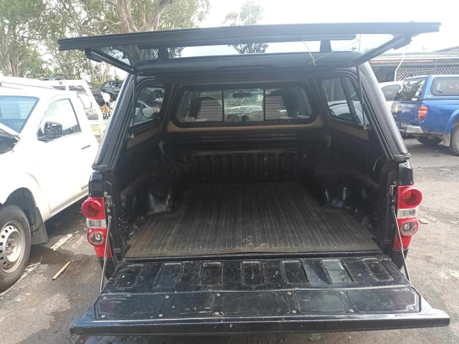 A Black Truck with a Canopy on Top of It is Parked in a Parking Lot — South West 4WD Wreckers In Brisbane, QLD