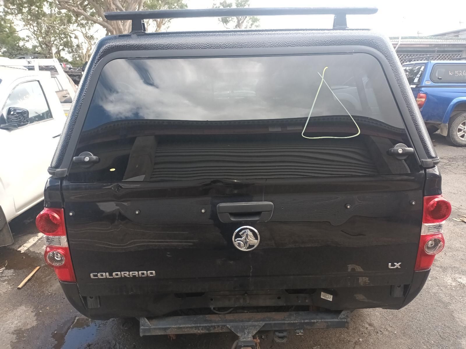 A Black Truck with a Canopy on Top of It is Parked in a Parking Lot — South West 4WD Wreckers In Brisbane, QLD