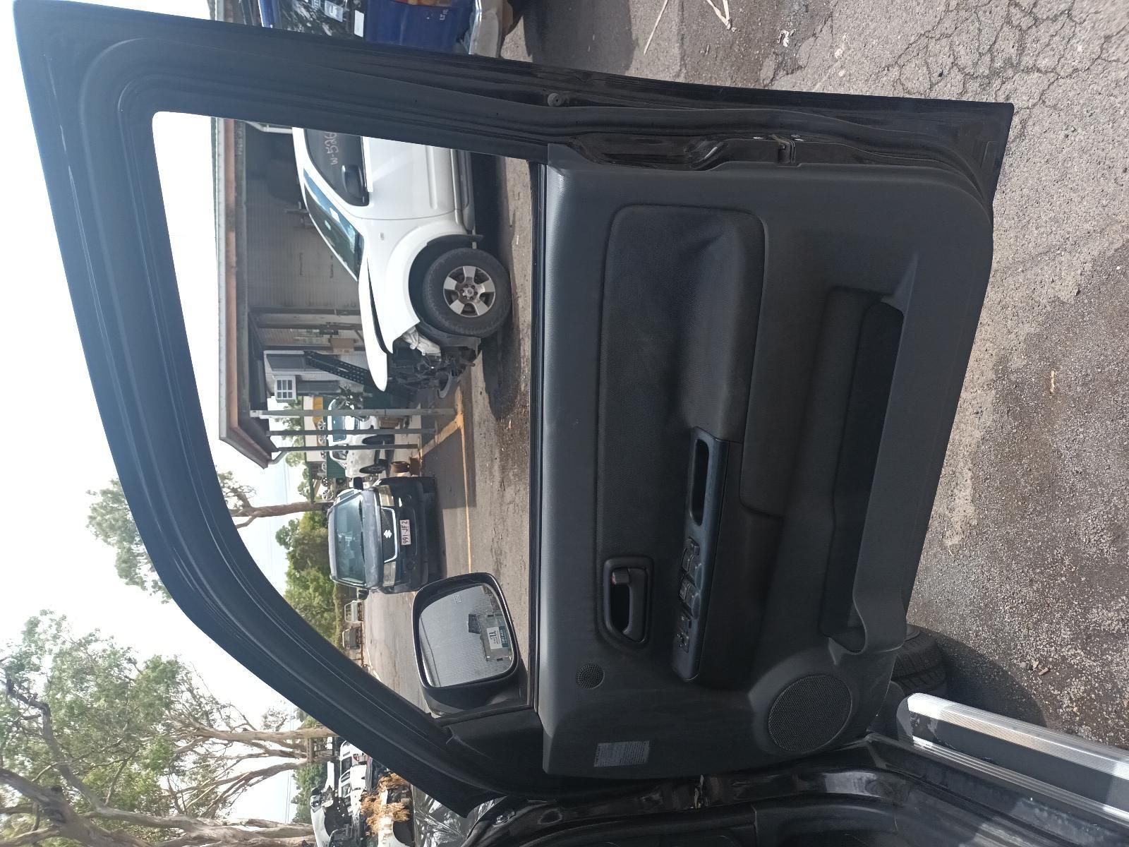 A Black Car with the Door Open and a White Car in the Background — South West 4WD Wreckers In Brisbane, QLD