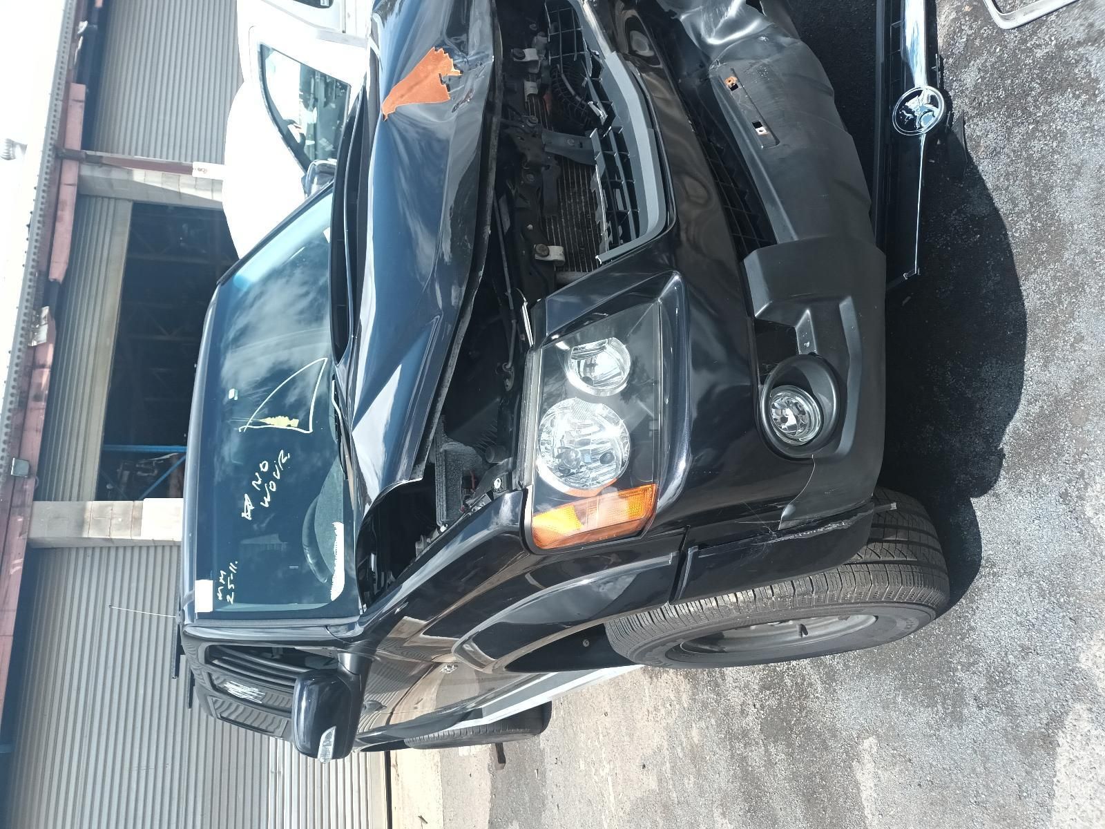 A Black Car with the Hood Open is Parked in Front of a Building — South West 4WD Wreckers In Brisbane, QLD