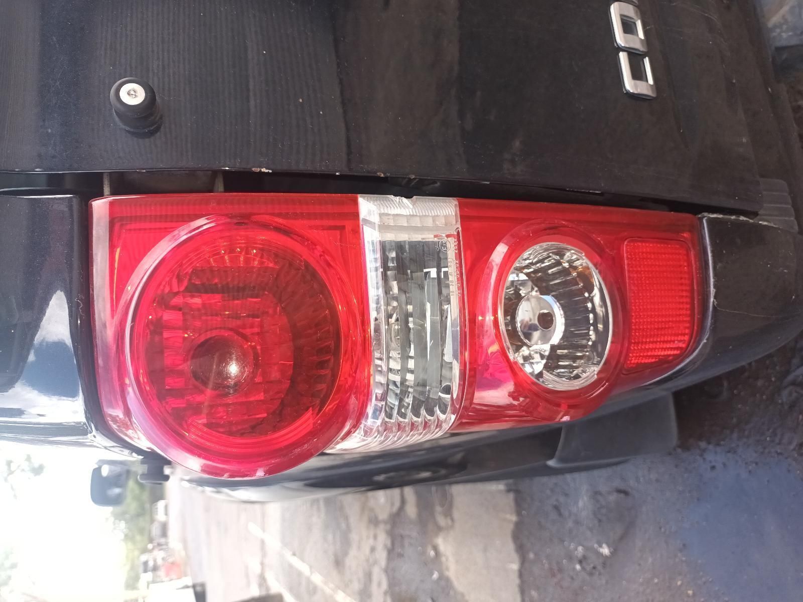 A Black Car with a Red Tail Light is Parked on the Side of the Road — South West 4WD Wreckers In Brisbane, QLD