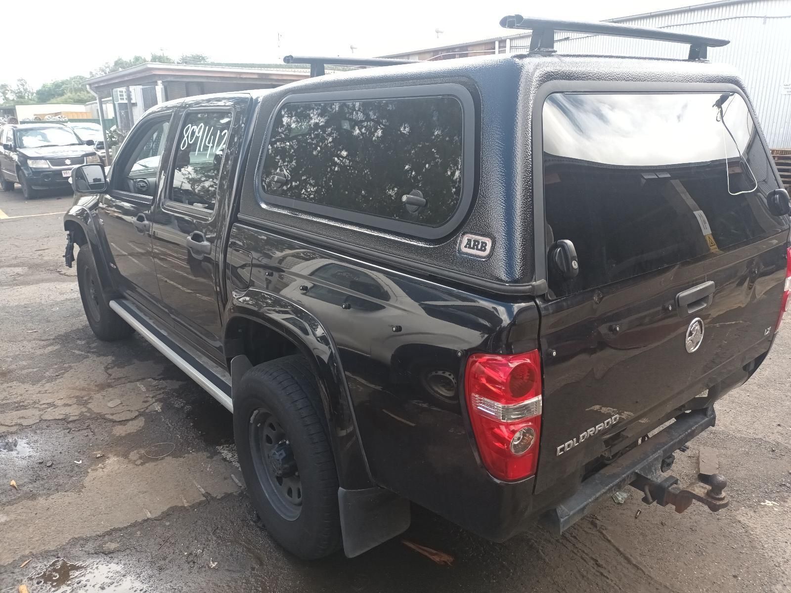 A Black Truck with a Canopy on Top of It is Parked in a Parking Lot — South West 4WD Wreckers In Brisbane, QLD
