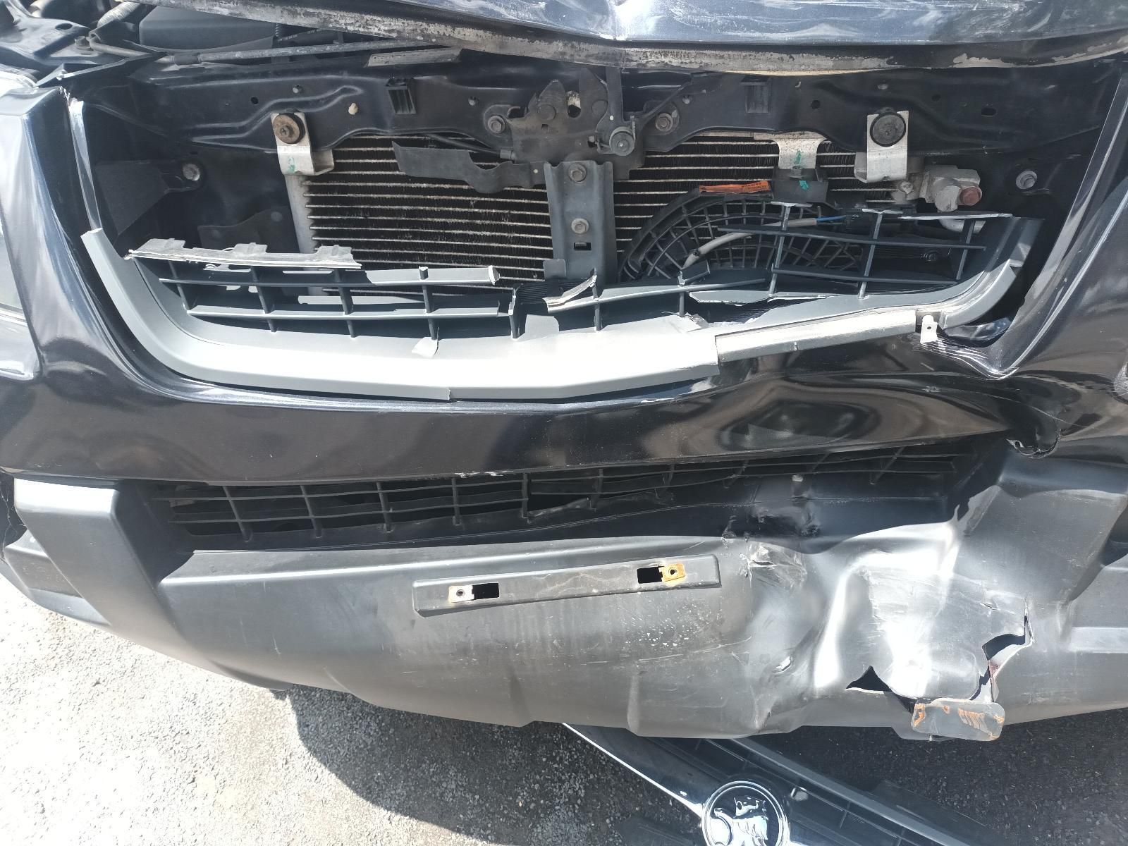 A Black Car with a Damaged Front Bumper is Parked on the Side of the Road — South West 4WD Wreckers In Brisbane, QLD
