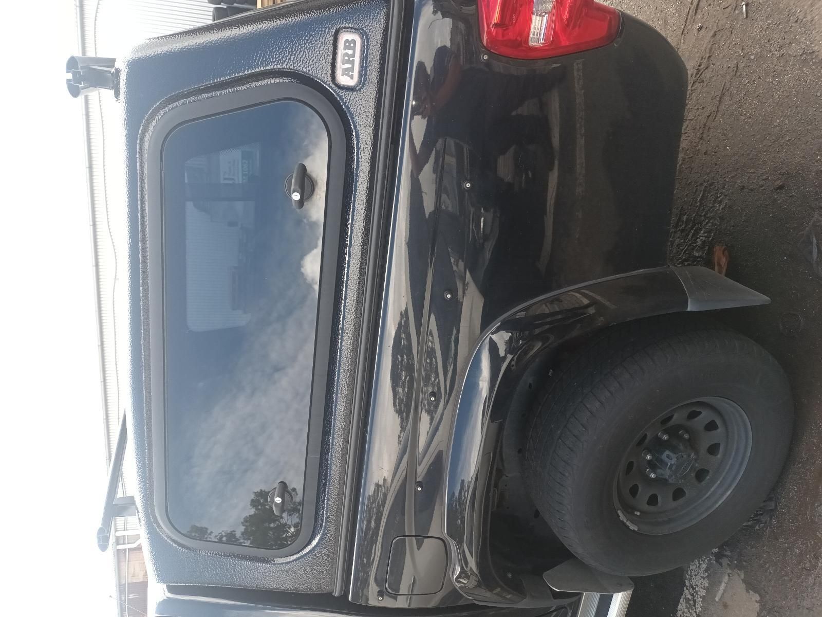 A Black Truck with a Canopy on Top of It is Parked on the Side of the Road — South West 4WD Wreckers In Brisbane, QLD