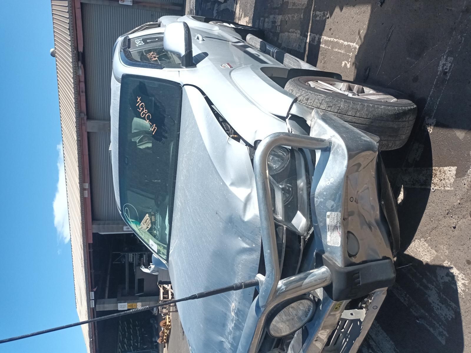 A Damaged Car is Parked in Front of a Garage — South West 4WD Wreckers in Harristown, QLD