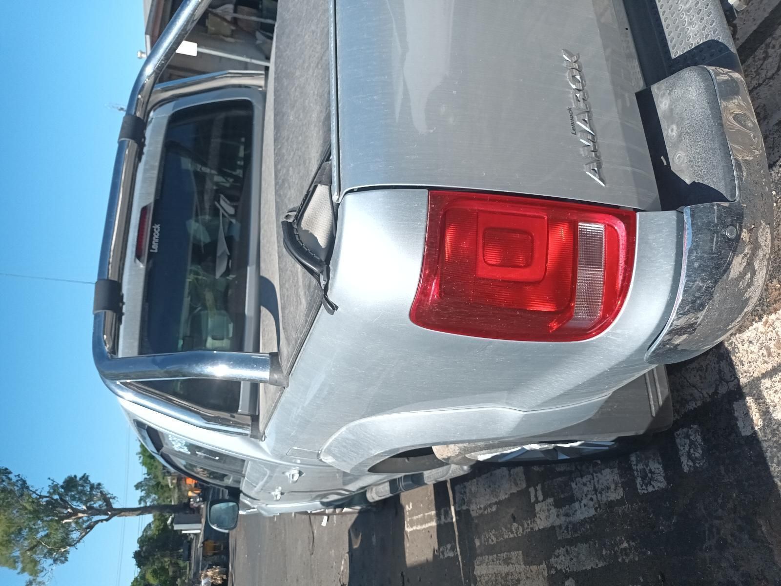 A Silver Pickup Truck with a Red Tail Light is Parked on the Side of the Road — South West 4WD Wreckers in Harristown, QLD