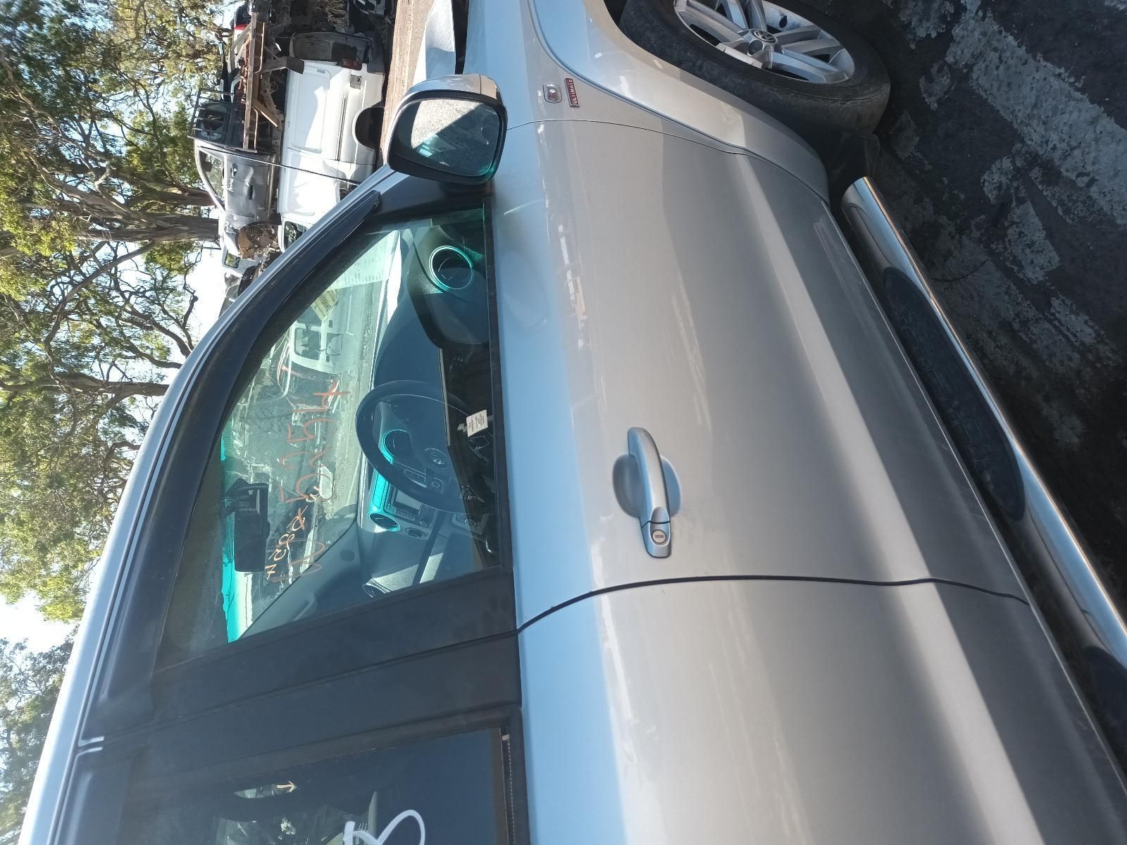 A Silver Car is Parked in a Parking Lot with Trees in the Background — South West 4WD Wreckers in Harristown, QLD