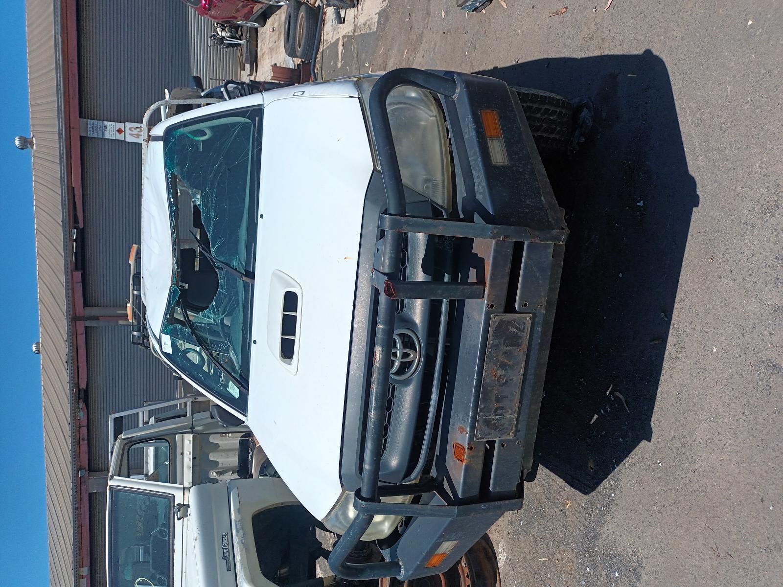 A White Toyota Truck is Parked on the Side of the Road — South West 4WD Wreckers in Harristown, QLD