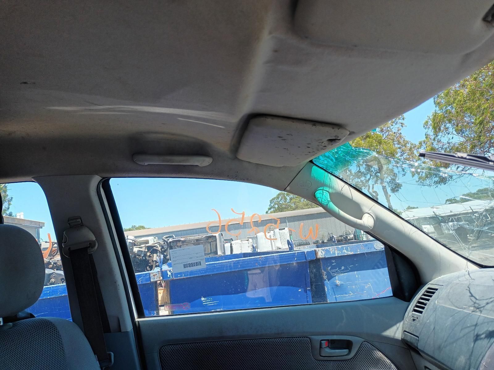 A Car is Parked in a Parking Lot with a Blue Fence in the Background — South West 4WD Wreckers in Harristown, QLD