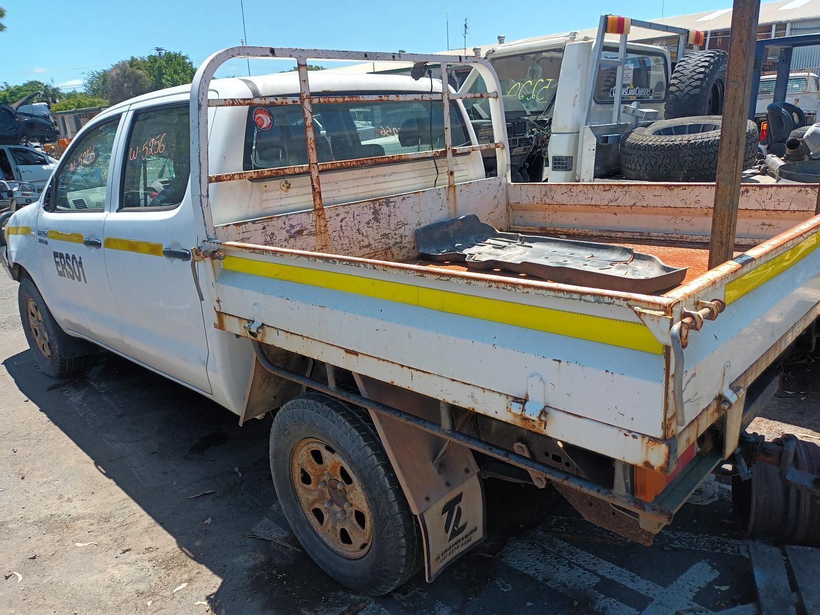 A White Truck with a Yellow Stripe on the Back is Parked in a Parking Lot — South West 4WD Wreckers in Harristown, QLD