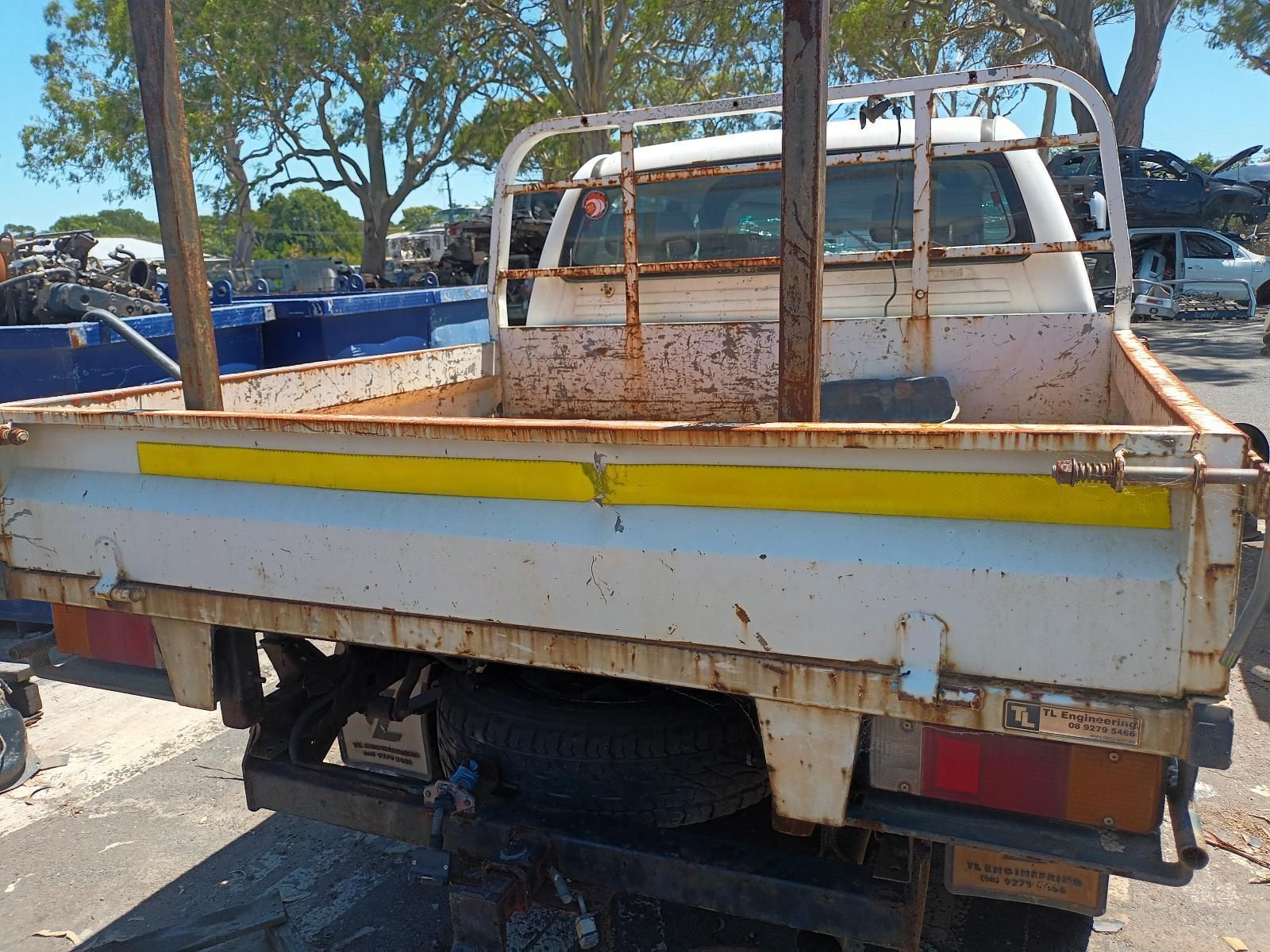 A White Truck with a Yellow Stripe on the Back is Parked on the Side of the Road — South West 4WD Wreckers in Harristown, QLD