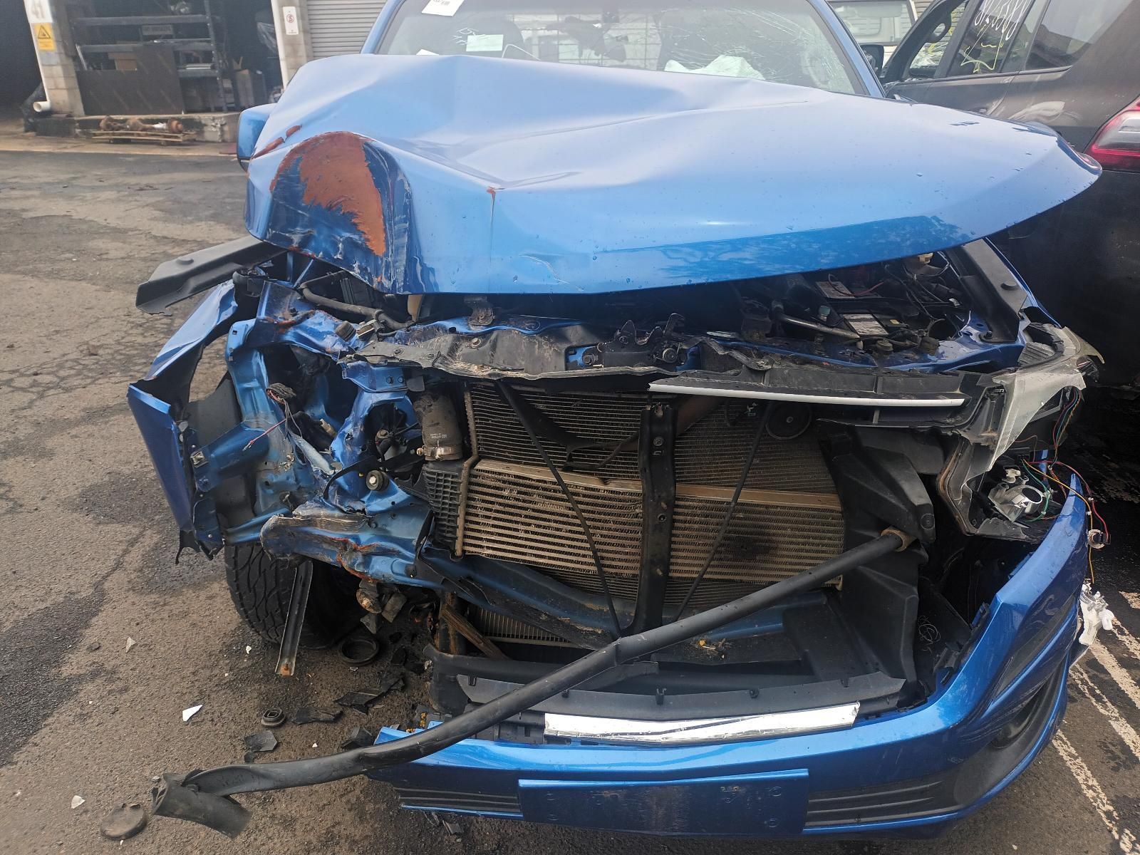 A Blue Car with a Damaged Front End is Parked in a Parking Lot — South West 4WD Wreckers In Brisbane, QLD