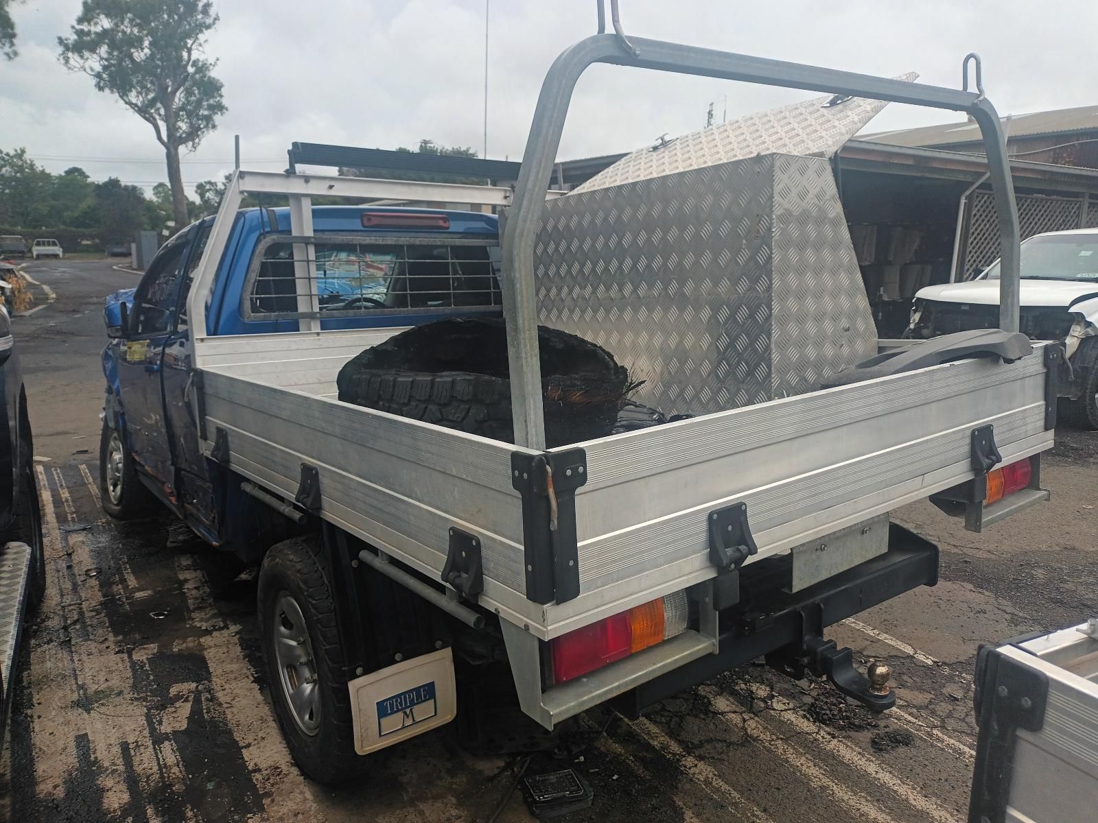 A Blue Truck with a Tray on the Back is Parked in a Parking Lot — South West 4WD Wreckers In Brisbane, QLD