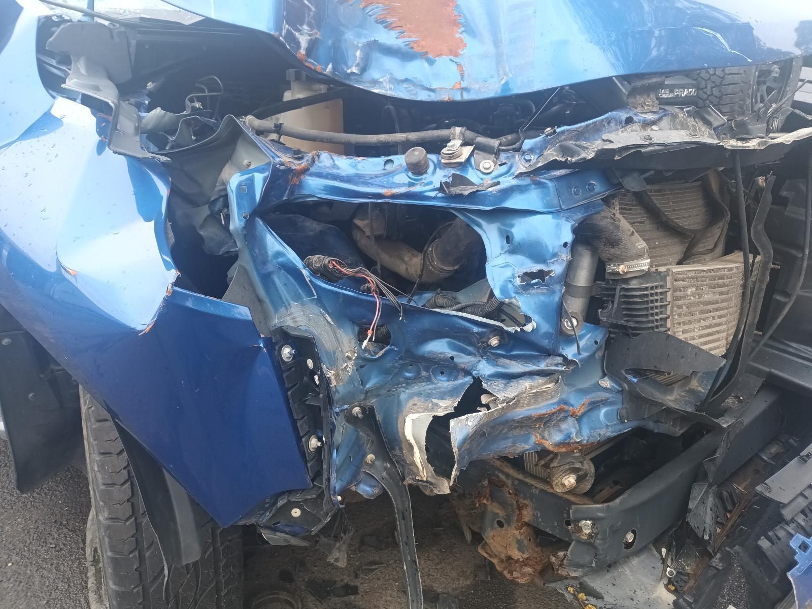 A Blue Car with a Damaged Front End is Parked on the Side of the Road — South West 4WD Wreckers In Brisbane, QLD