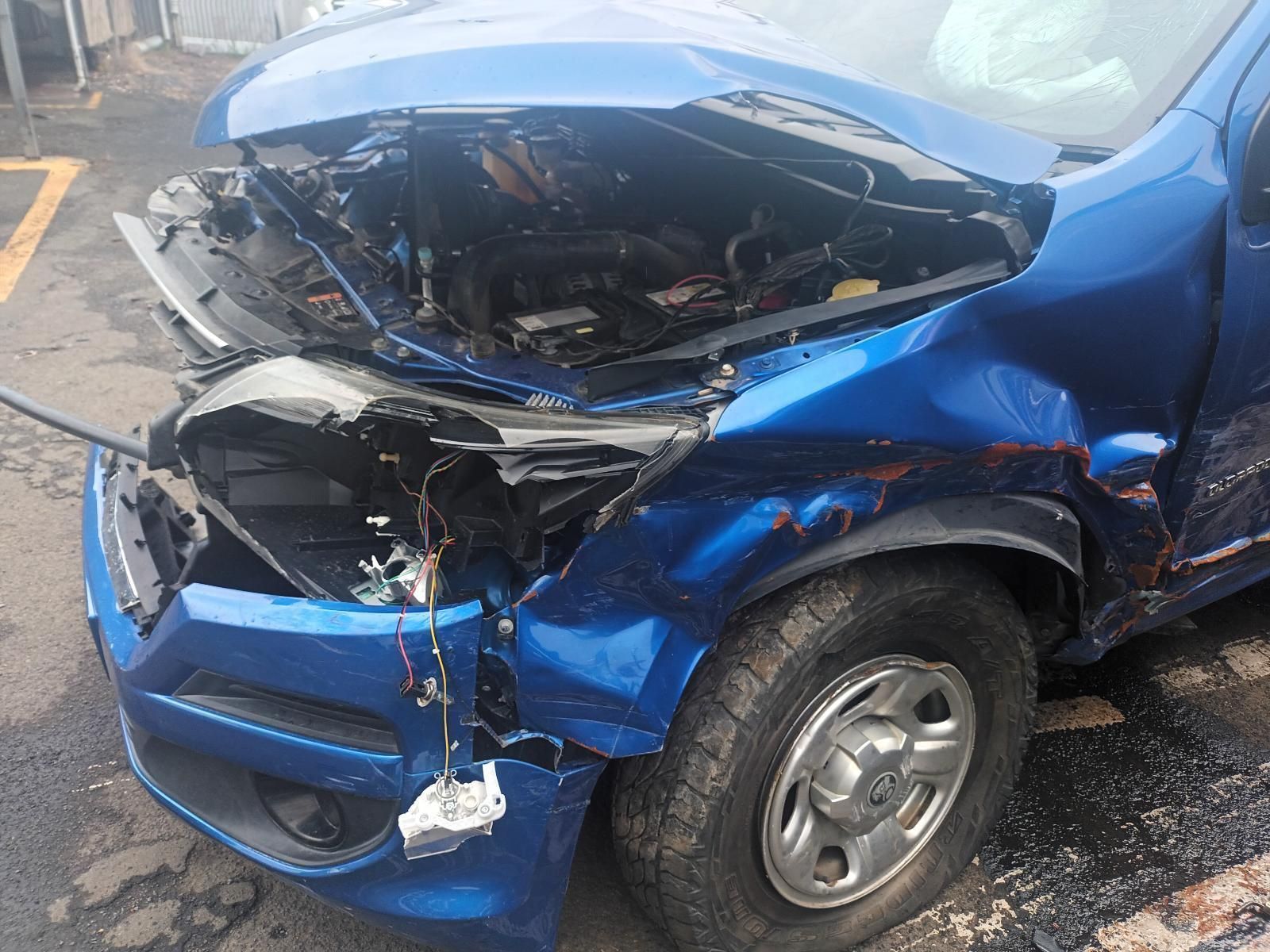 A Blue Car with a Damaged Front End is Parked in a Parking Lot — South West 4WD Wreckers In Brisbane, QLD