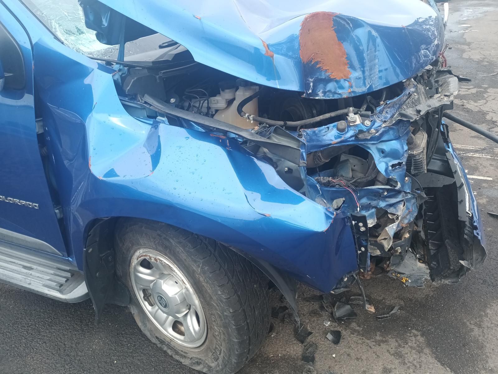 A Blue Car with a Damaged Hood is Parked on the Side of the Road — South West 4WD Wreckers In Brisbane, QLD