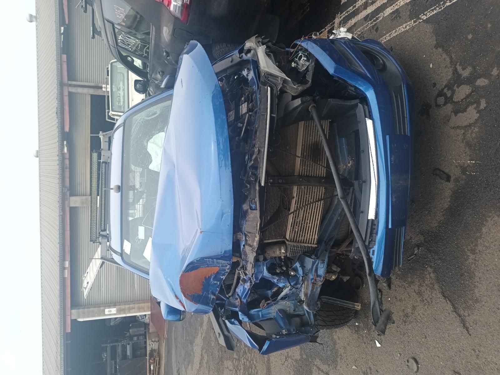 A Blue Car with a Damaged Front End is Parked in a Parking Lot — South West 4WD Wreckers In Brisbane, QLD