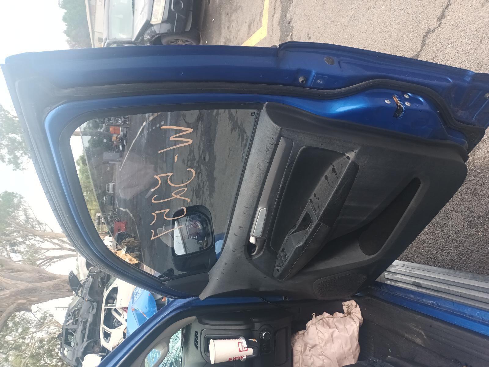 A Blue Car with the Door Open is Parked in a Parking Lot — South West 4WD Wreckers In Brisbane, QLD