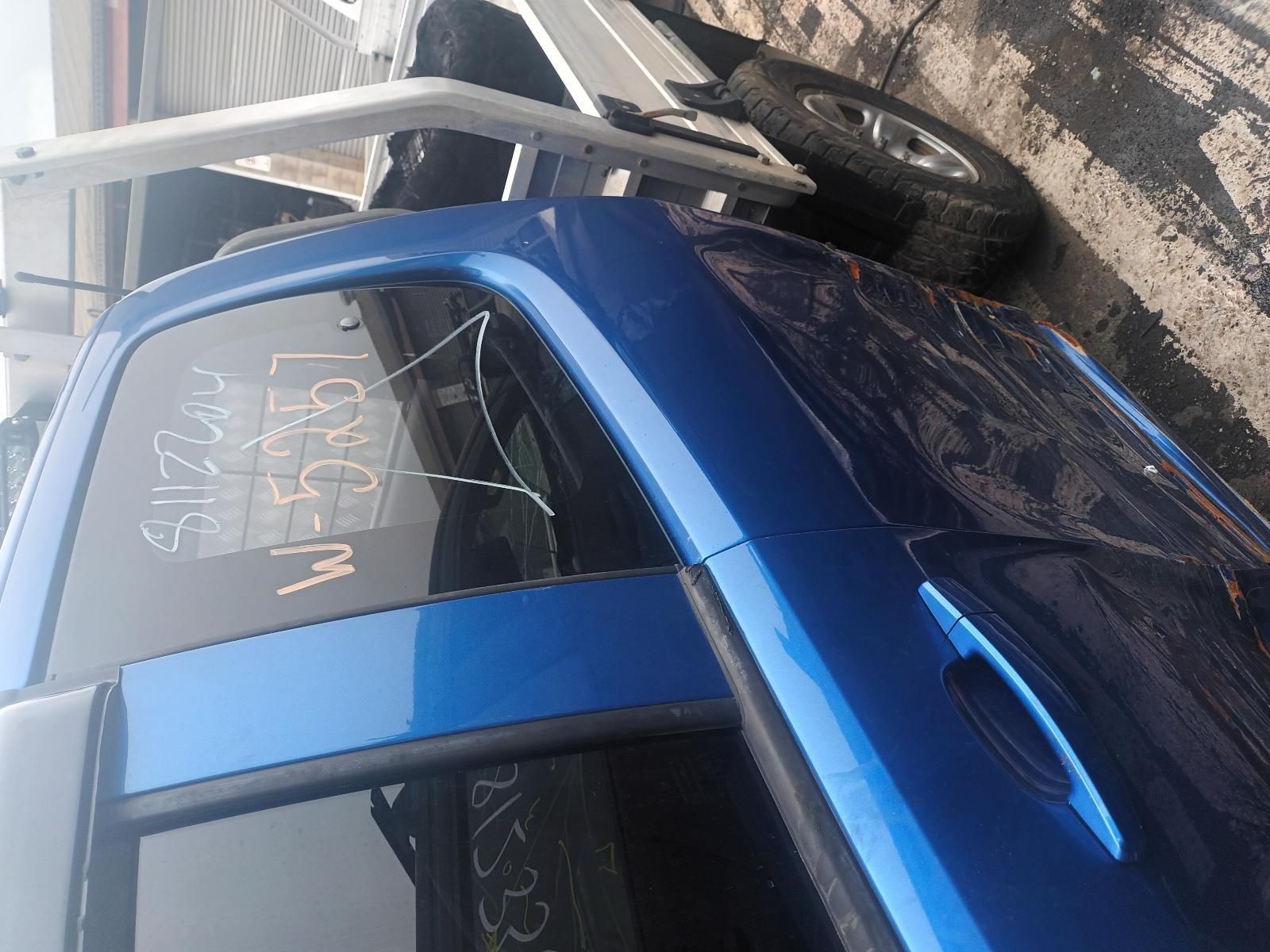 A Blue Car is Parked on the Side of the Road Next to a Trailer — South West 4WD Wreckers In Brisbane, QLD