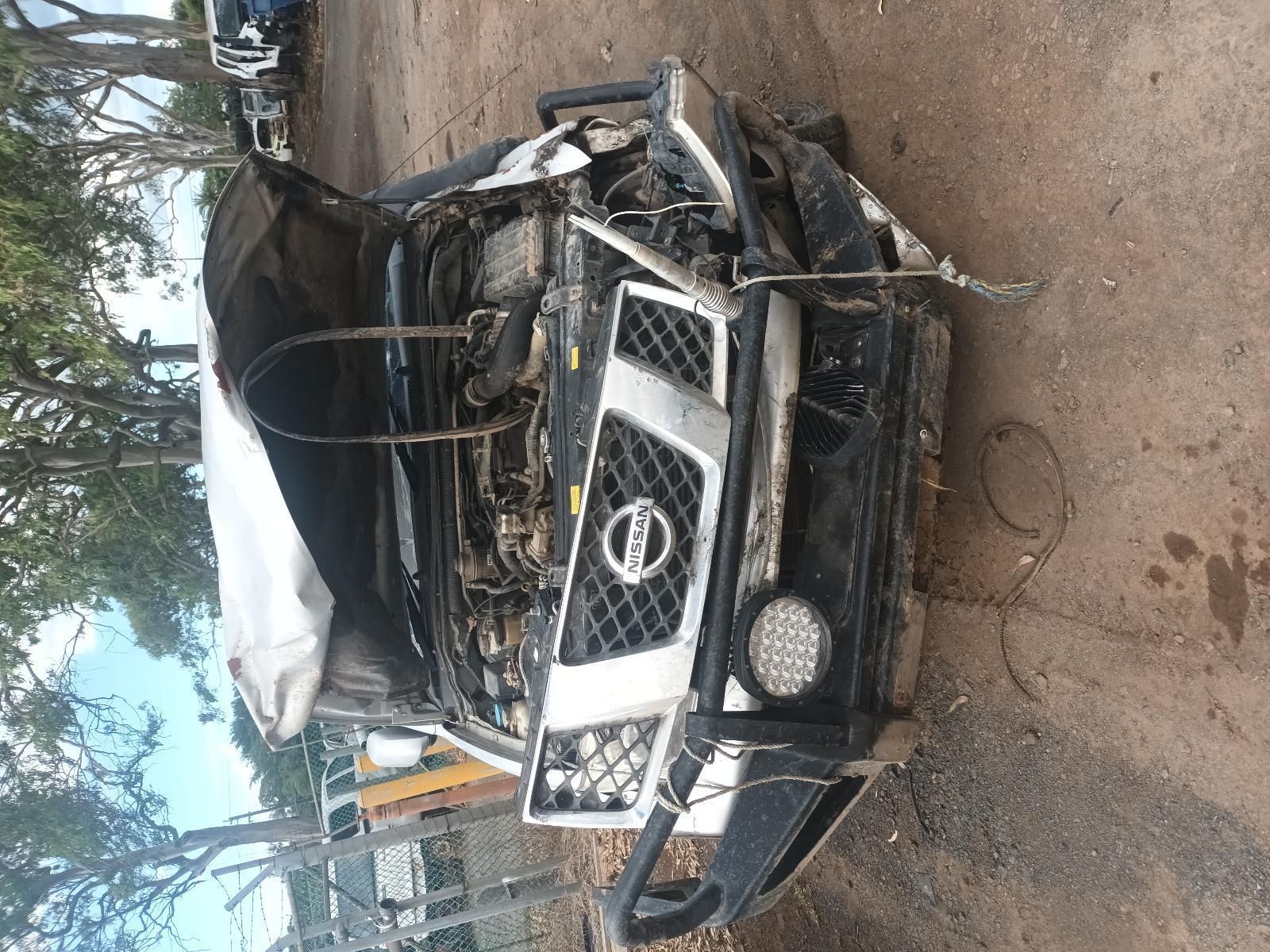 A Nissan Car with the Hood Open is Sitting on a Dirt Road — South West 4WD Wreckers In Brisbane, QLD