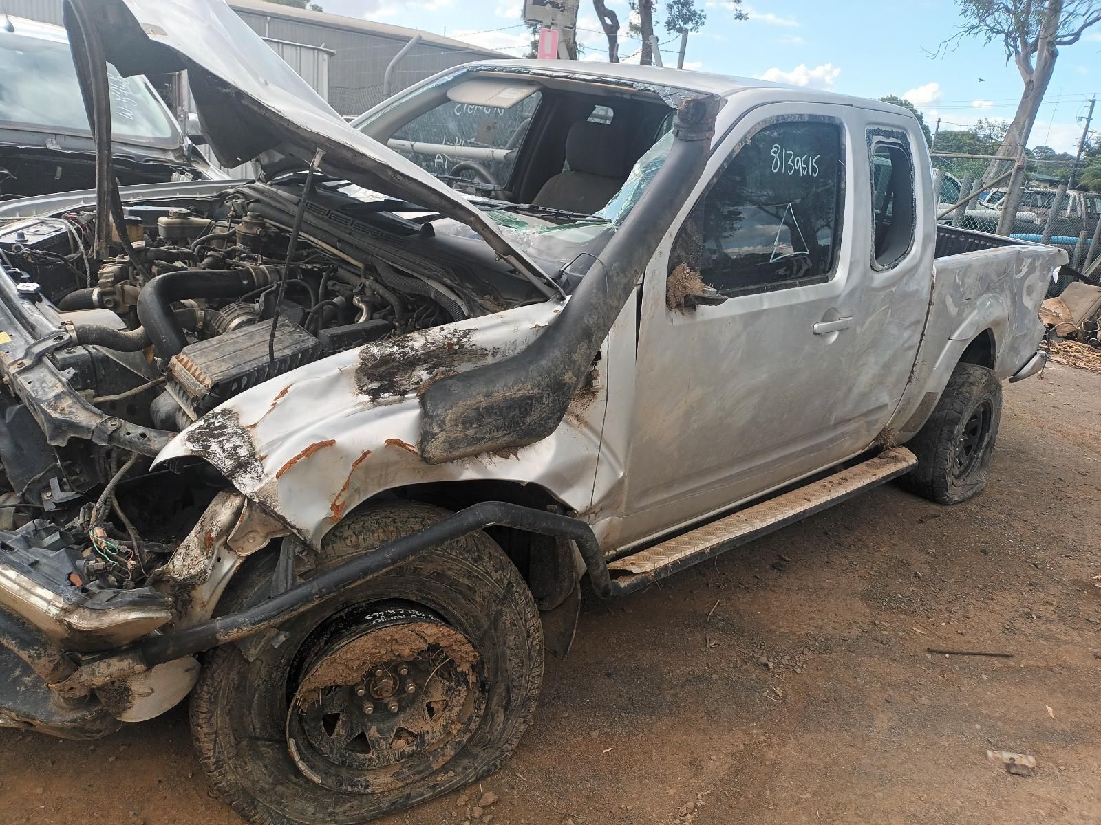 A Silver Truck with the Hood Up is Sitting in the Dirt — South West 4WD Wreckers In Brisbane, QLD