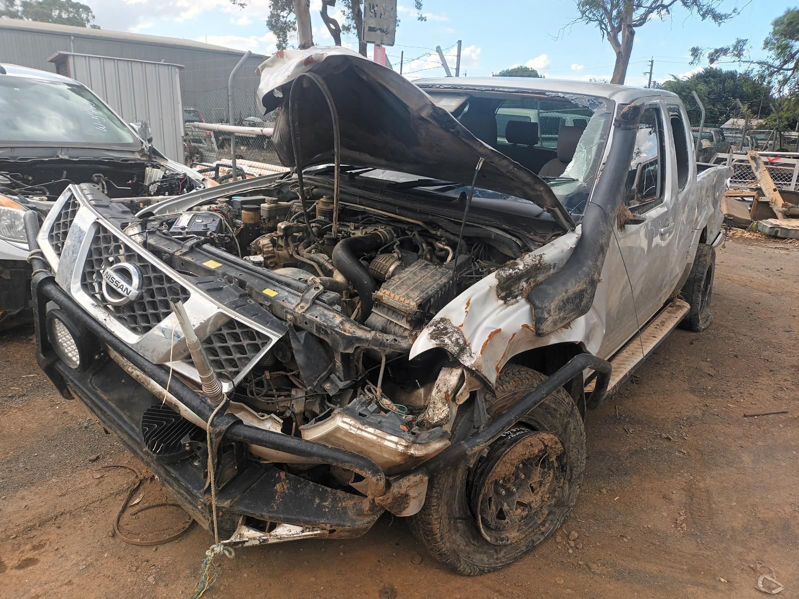 A Nissan Pickup Truck with Its Hood Up is Sitting in a Scrap Yard — South West 4WD Wreckers In Brisbane, QLD