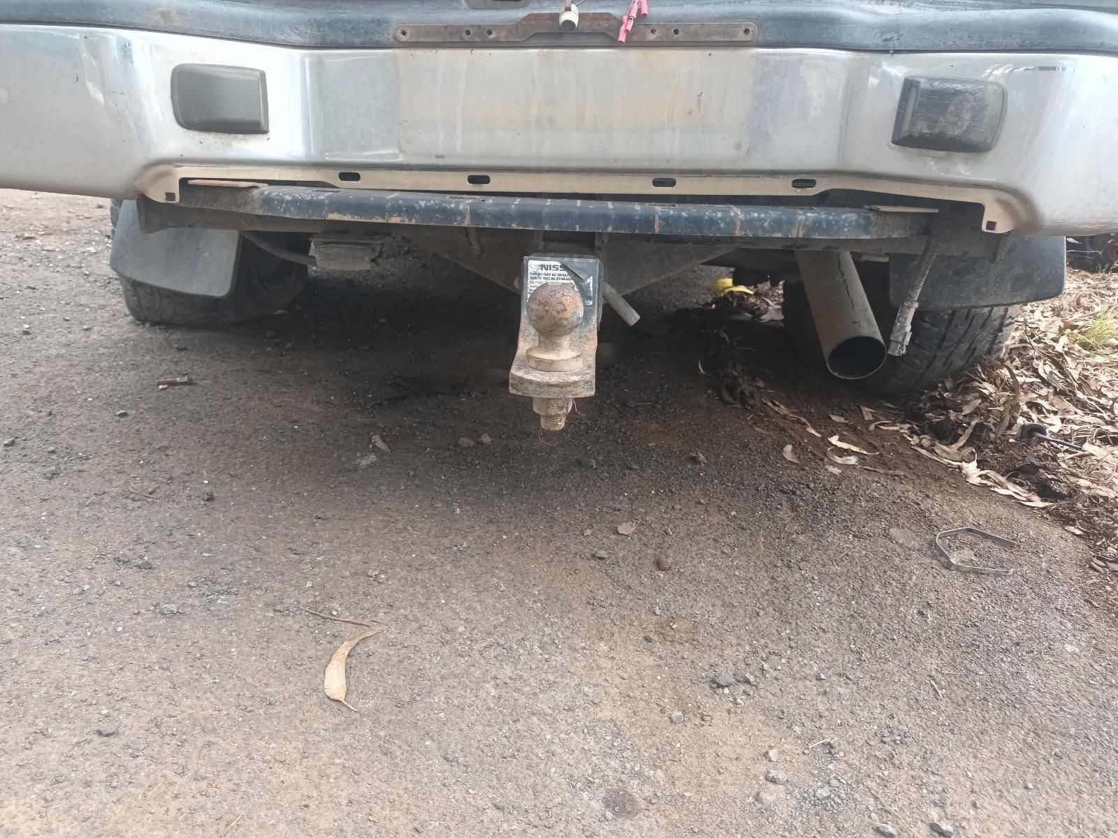 A Silver Truck with a Trailer Attached to It is Parked on the Side of the Road — South West 4WD Wreckers In Brisbane, QLD