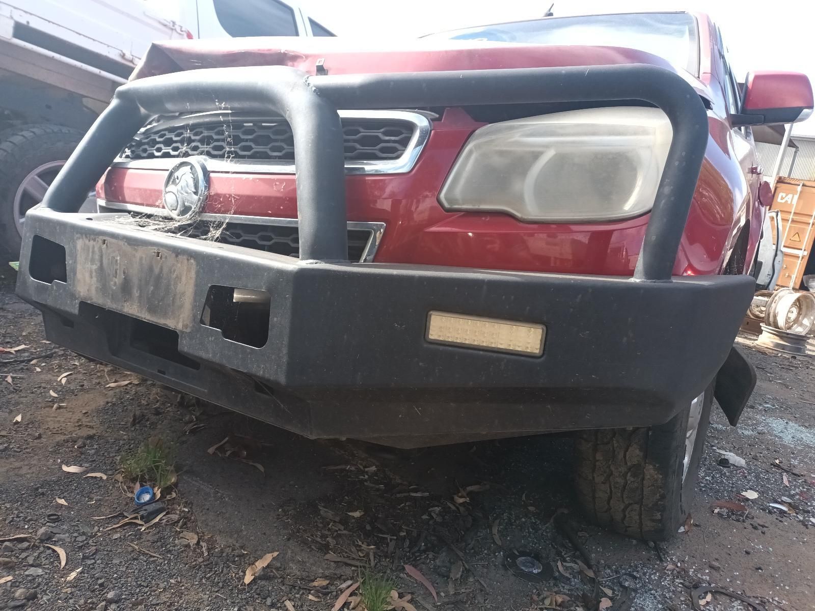 A Red Truck with a Black Bumper is Parked in a Dirt Lot — South West 4WD Wreckers In Brisbane, QLD