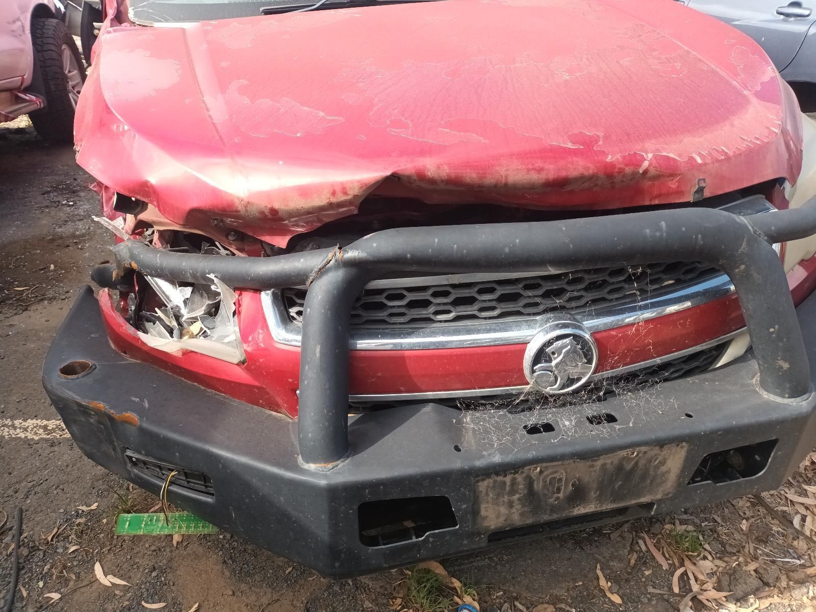 A Red Car with a Black Bumper is Parked in a Lot — South West 4WD Wreckers In Brisbane, QLD