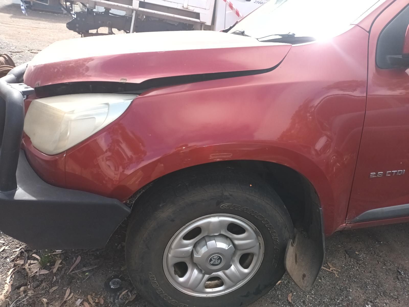 A Red Truck with a Damaged Hood is Parked in the Dirt — South West 4WD Wreckers In Brisbane, QLD