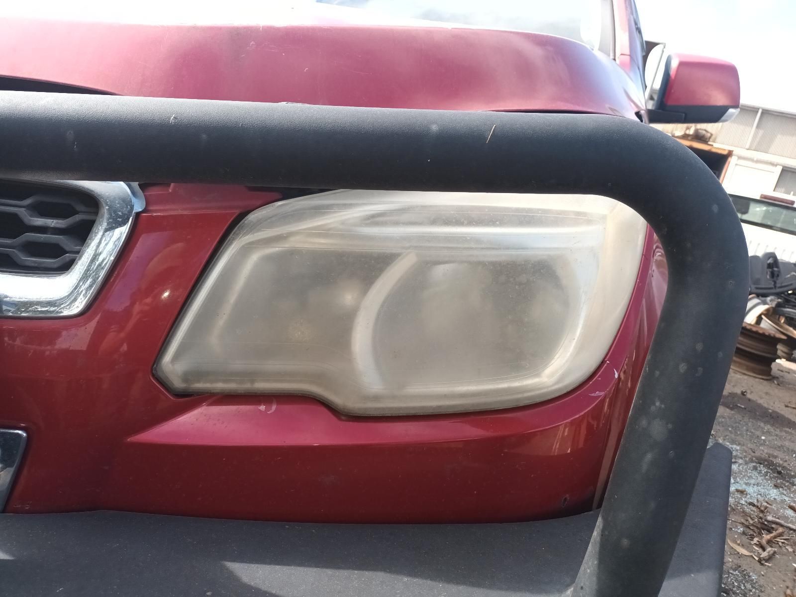 A Close Up of a Red Car's Headlight with a Black Bumper — South West 4WD Wreckers In Brisbane, QLD