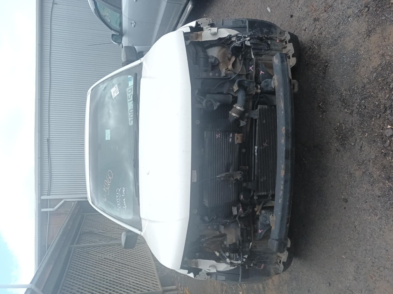 A White Car with a Broken Windshield is Parked on the Side of the Road — South West 4WD Wreckers In Brisbane, QLD