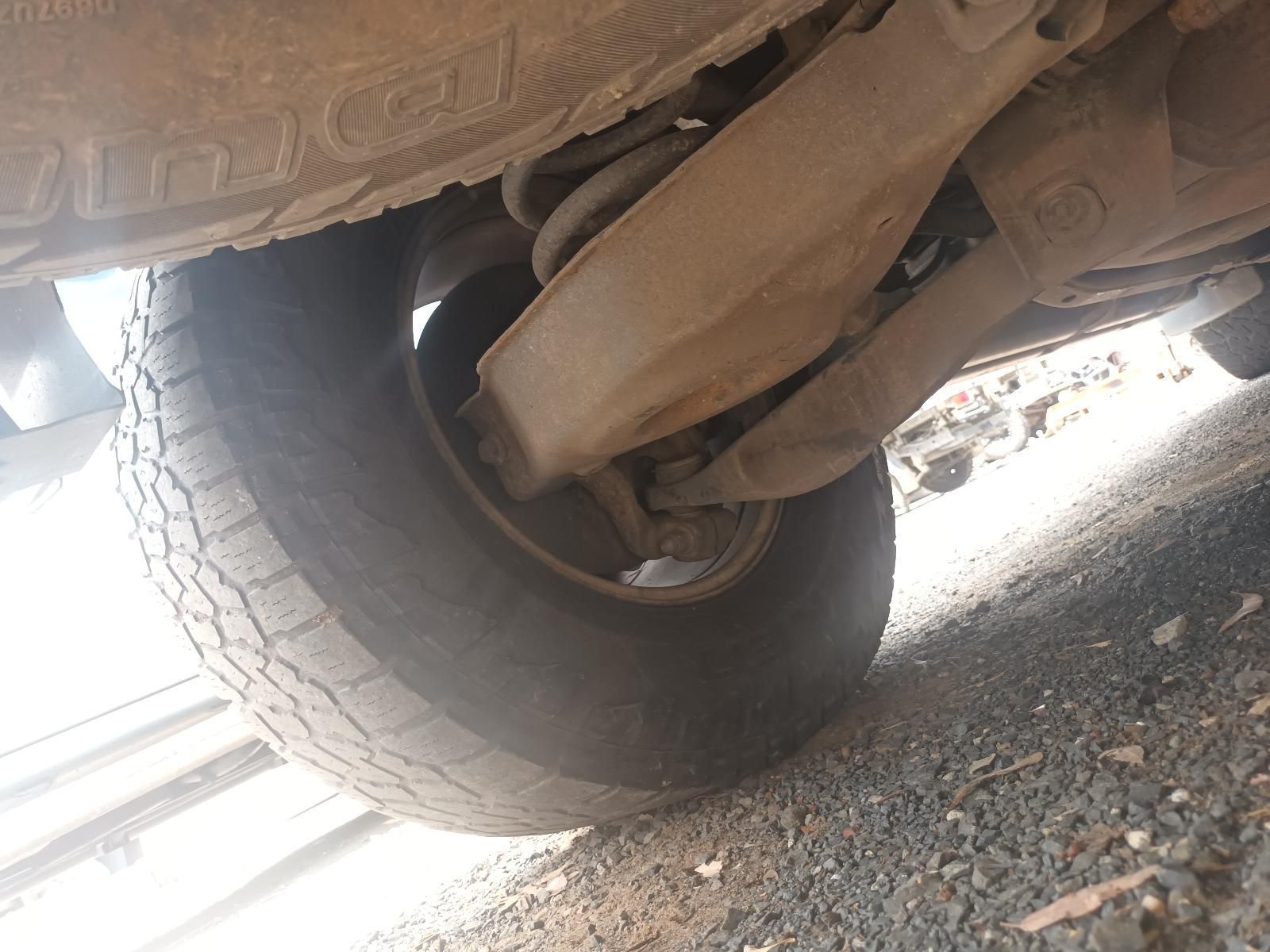 A Close Up of the Underside of a Car with a Tire on the Ground — South West 4WD Wreckers In Brisbane, QLD
