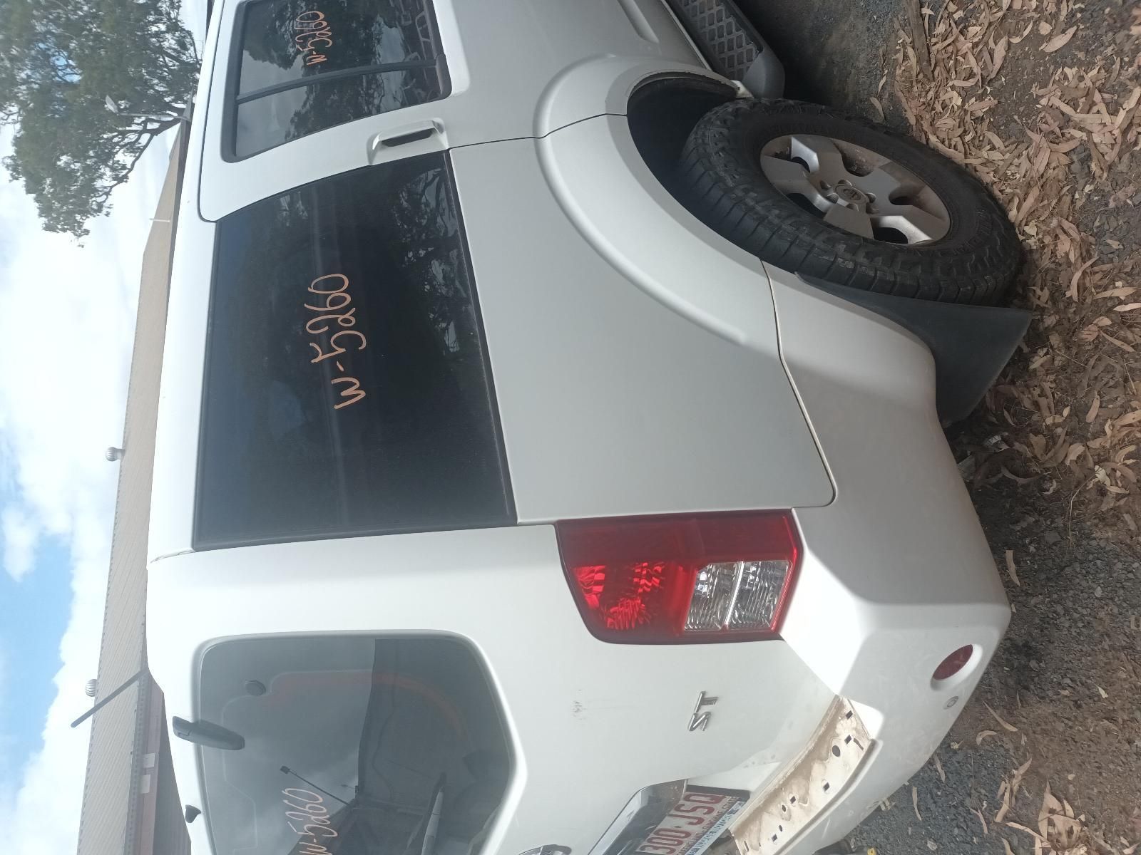 A White Nissan Pathfinder is Parked on the Side of the Road — South West 4WD Wreckers In Brisbane, QLD