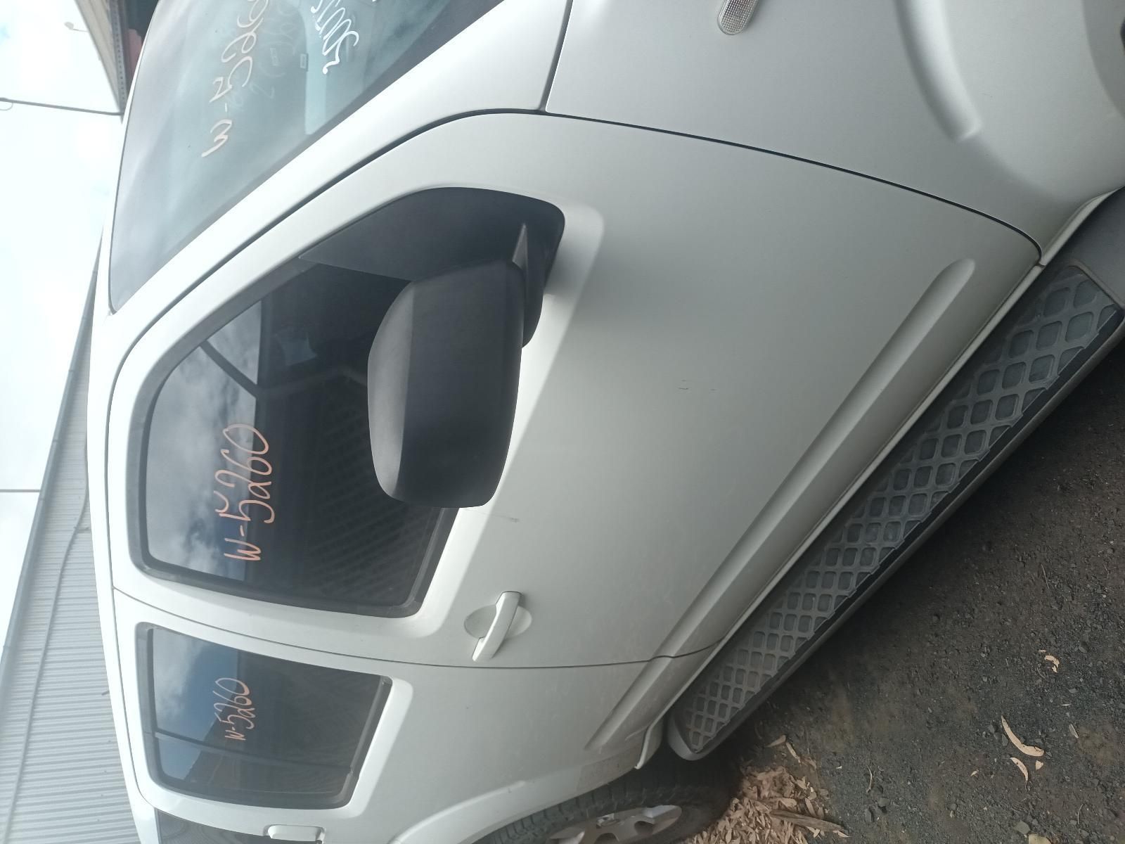 A White Car with a Broken Door is Parked on the Side of the Road — South West 4WD Wreckers In Brisbane, QLD